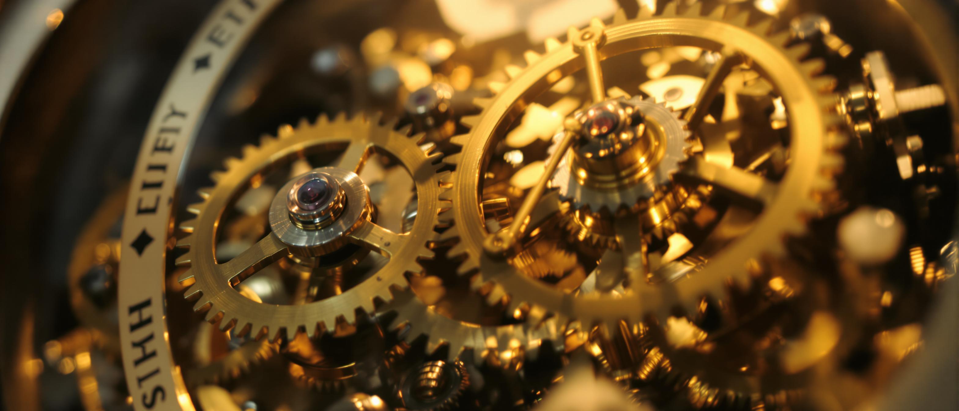 Close-up photograph of intricate clockwork gears bathed in soft light, symbolizing the efficiency of automated processes.