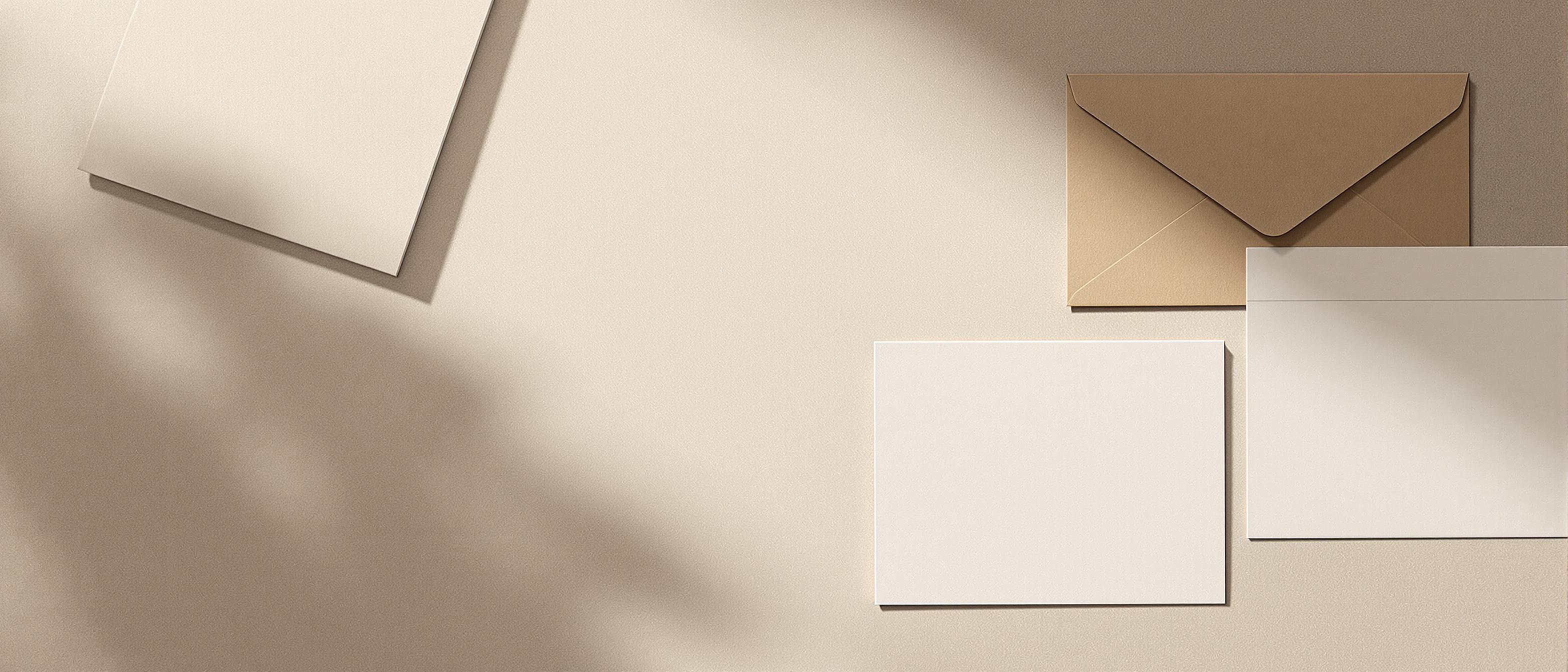 An array of stationery including envelopes and business cards laid out on a flat surface with a shallow depth of field.